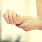 Woman holding her wrist -
