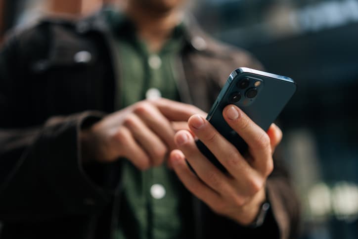 Person using a smartphone outdoors in an urban setting