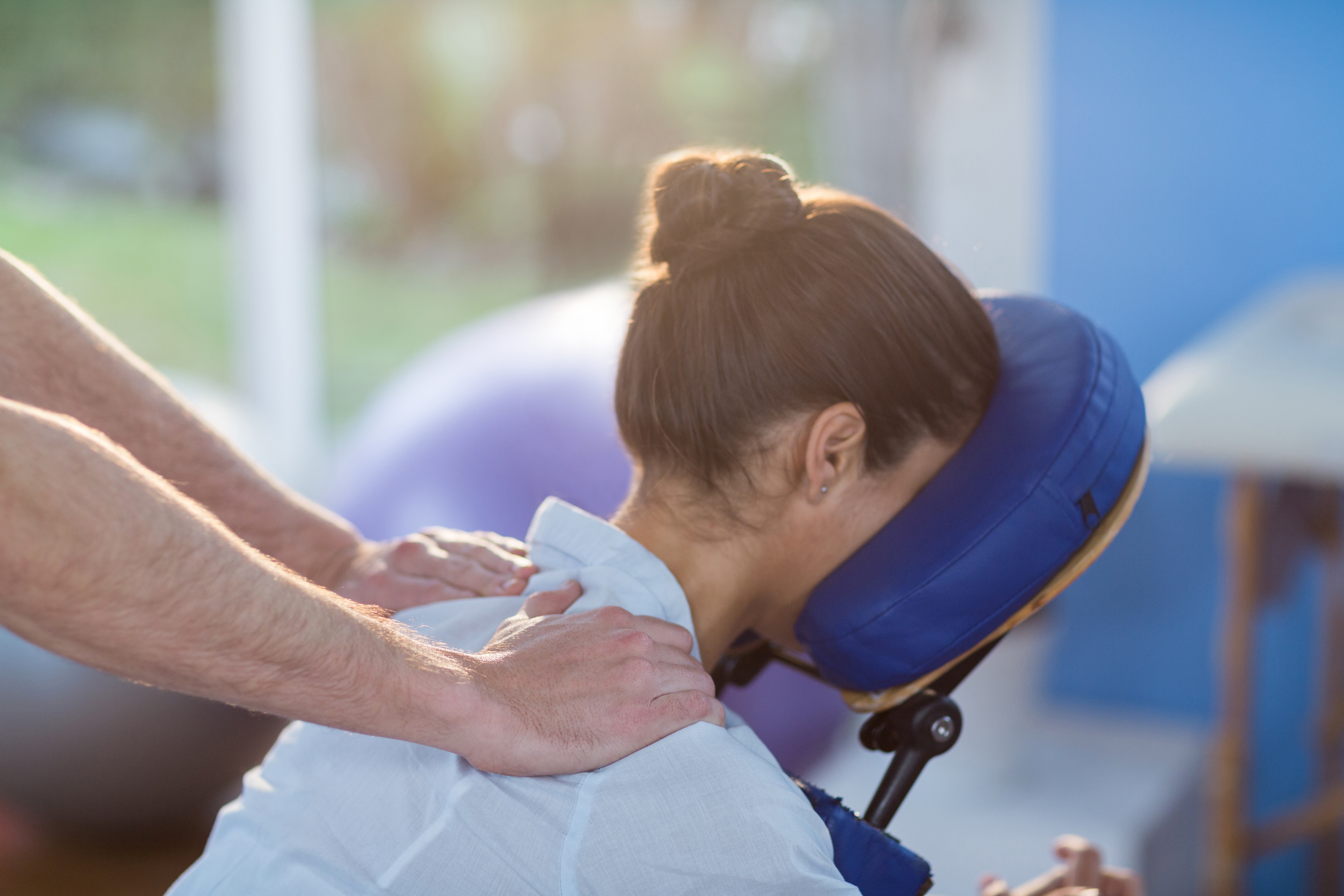 an-in-home-massage-therapist-massaging-their-client-on-a-mobile-massage-chair