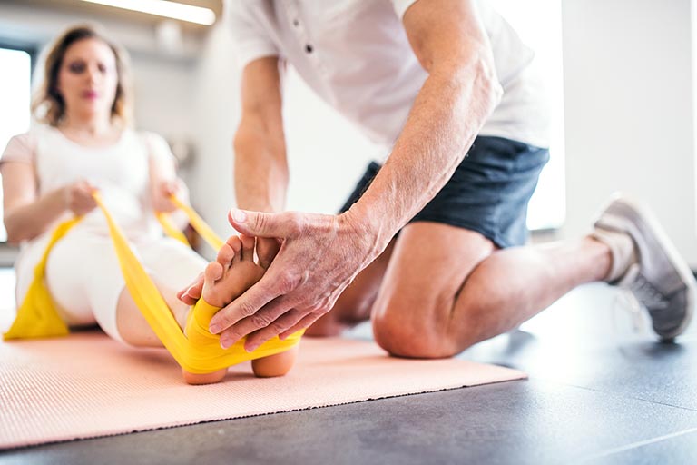 in-home-physical-therapist-helping-his-patient-use-a-stretch-band