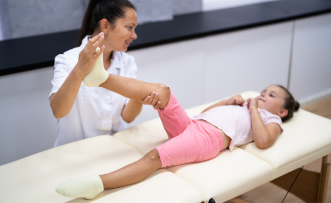 A child receives gentle leg support during pediatric physiotherapy in Edmonton