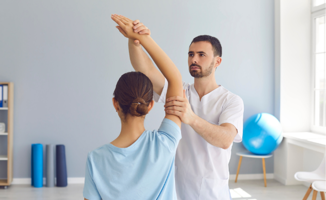 Physiotherapist guiding shoulder movement as part of WCB physiotherapy