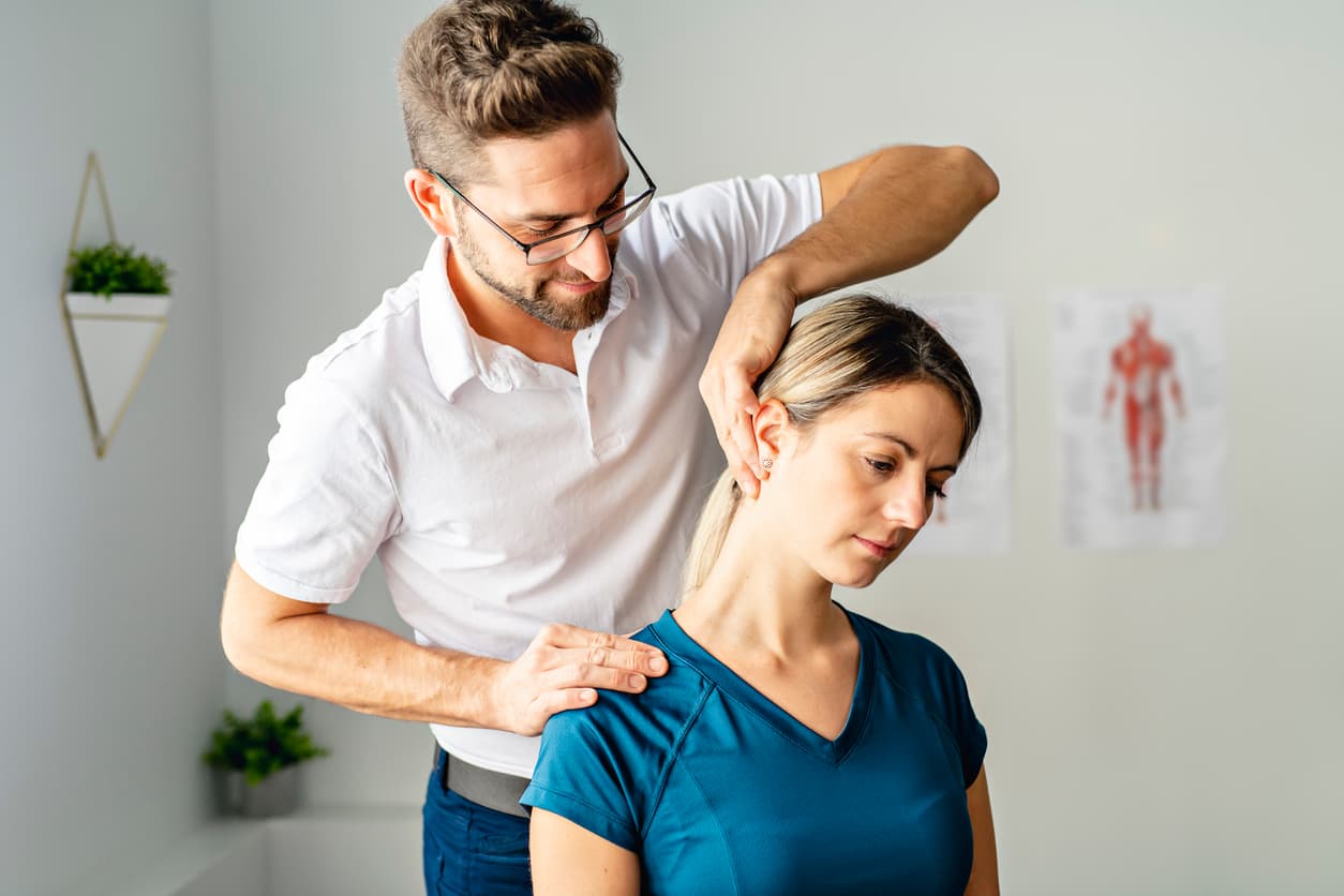 Chiropractor performing a neck adjustment and posture treatment on a woman